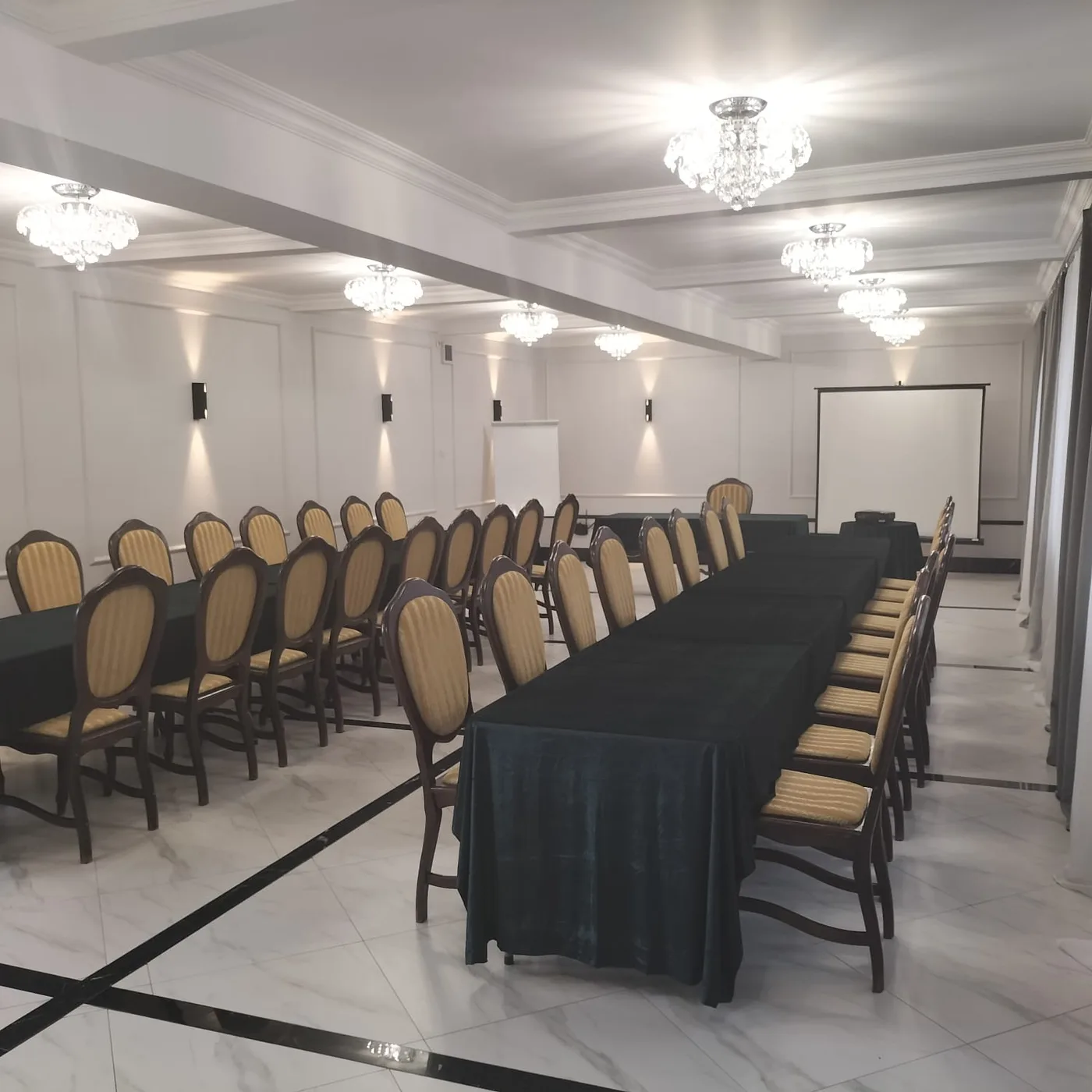 Sala konferencyjna w ustawieniu podkowy z ekranem projekcyjnym