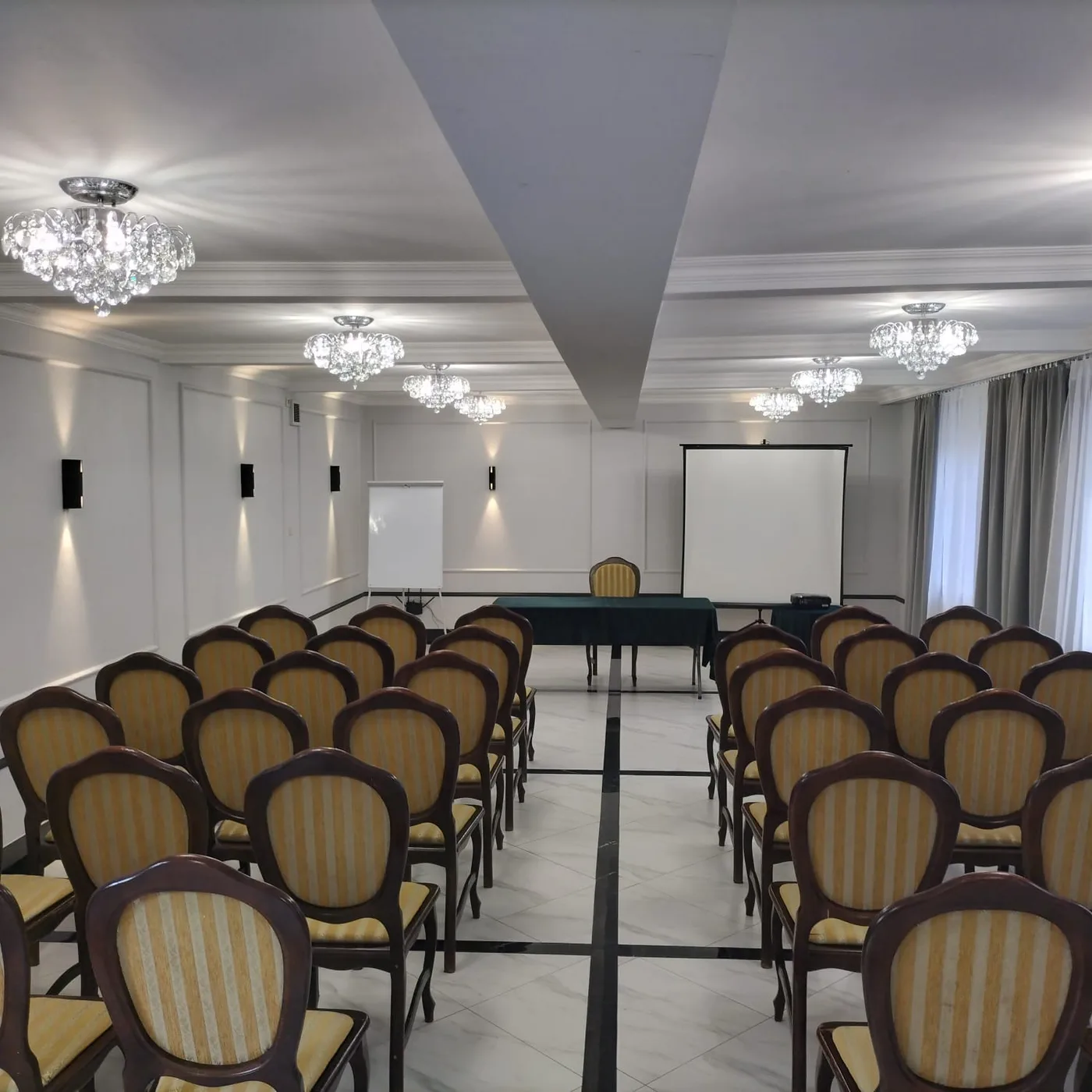 Sala konferencyjna w Dworku Biała Dama w ustawieniu szkolnym, rzędy krzeseł przed ekranem